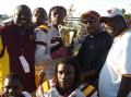 Glades Central Players take a picture with the Muck Bowl Trophy